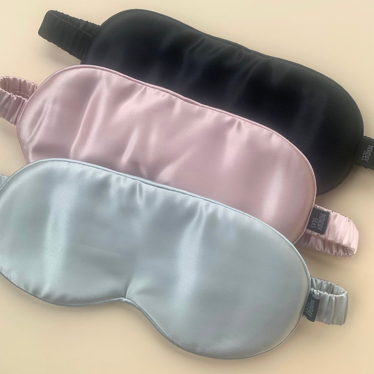 Silk eye masks in black, pink, and silver by Monday Silks. Premium sleep aid for skin protection and comfort.