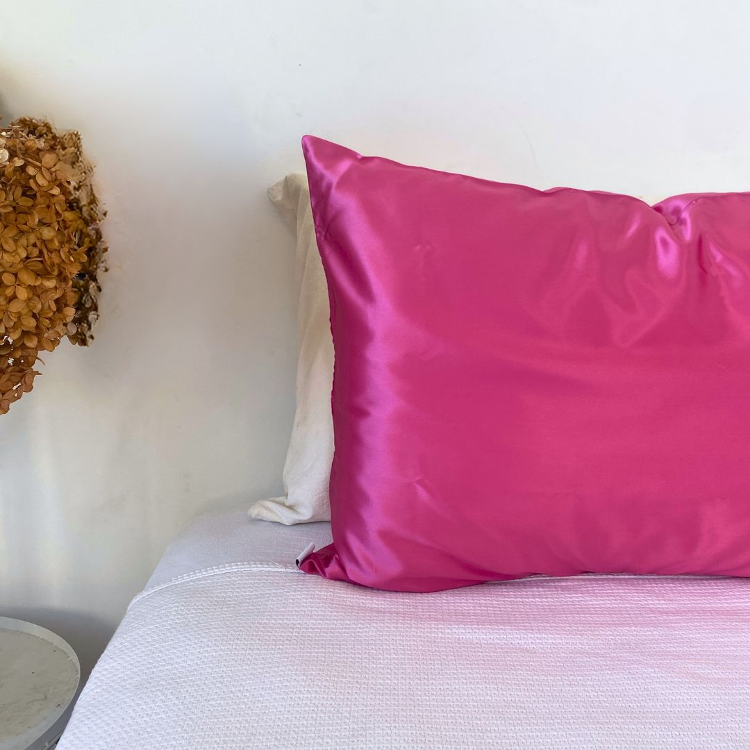 Silk Pillowcase Fuchsia by Monday Silks NZ on bed, showcasing vibrant color and smooth texture for luxury sleep and reduced bed hair.