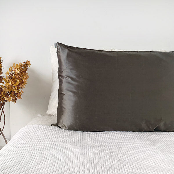 Charcoal silk pillowcase by Monday Silks NZ on a white bed, made from pure mulberry silk for anti bed hair and skin hydration benefits.